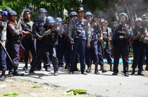 A police officer points his rifle at street level in Sittwe in June 2012. The government claims a total of 211 people died in the June and October violence; Human Rights Watch research indicates far greater loss of life. © 2012 Private