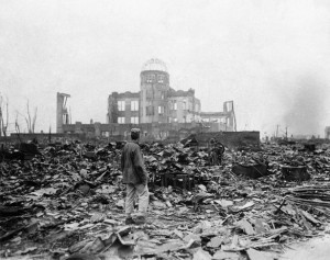 An allied correspondent stands in a sea of rubble before the shell of a building in Hiroshima September 8, 1945, a month after the first atomic bomb ever used in warfare was dropped by the US. (AP Photo/Stanley Troutman)