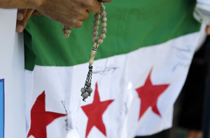 A Syrian community in Romania holds a rosary during a protest in front of the Syrian embassy in Bucharest