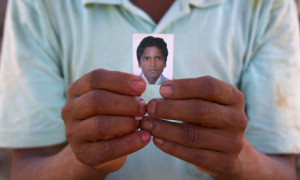 Tilak Bahadur Bishwakarma holds a photo of his son, Ganesh, 16, who died in Qatar from a cardiac arrest, six weeks after leaving Nepal. Photograph: Peter Pattisson/guardian.co.uk