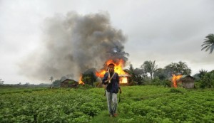 A resident of Rakhine State walks past burning homes during anti-Rohingya violence in Sittwe during summer 2012. The year since has seen similar incidents, increased hate speech, and the ghettoization of the Rohingya. (Source)