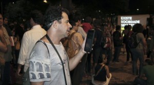 Cazú Barros participating in and reporting on a street protest in Rio de Janeiro, using a tablet. Credit: Fabiana Frayssinet/IPS