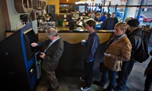 Customers line-up to use the world's first ever permanent bitcoin ATM at a coffee shop in Vancouver, British Columbia. Photograph: Andy Clark/Reuters