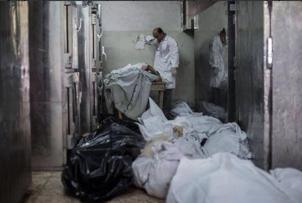 A doctor cries while standing among the bodies of dead children at Shifa Hospital's overflowing morgue. [Note: journalists have captured countless disturbing images today, though I've chosen not to show them here.
