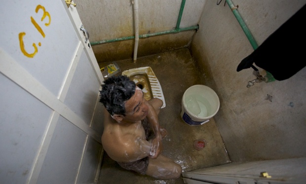 An Ibex worker washes himself in salt water in toilets. Pete Pattisson for the Guardian
