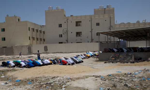 Migrant workers attend prayers at a makeshift mosque in a vast labour camp in Qatar. Photograph: Pete Pattisson for the Guardian
