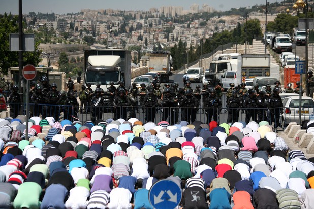 Palestinians in Jerusalem were compelled to pray in the street Friday after Israeli forces denied them entry to the Old City. (Saeed Qaq / APA images)