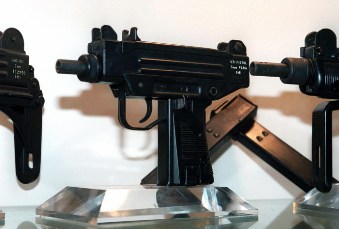 An Uzi pistol (C) is displayed next to the larger