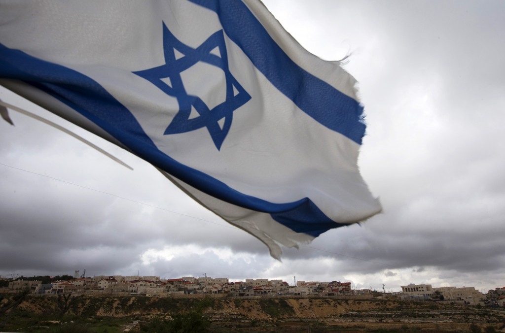 An Israeli flag flies on a hill near the West Bank Jewish settlement of Elazar, near Bethlehem March 17, 2013. REUTERS/Ronen Zvulun 