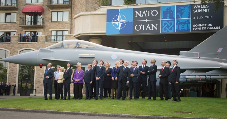 Heads of state from NATO membership countries, framed by a fighter jet, pose for a picture at their annual summit in Newport, Wales. (Image: NATO)