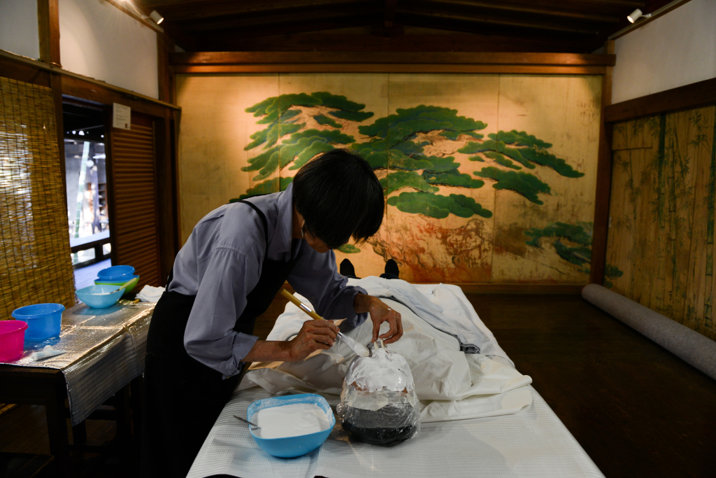 Kim Myong-hee, a Korean artist who has been living in Kyoto for almost four decades, puts plaster on Ryoma Yamanao, a young Japanese businessman, during a workshop for the Peace Mask East Asia project. (Noriko Hayashi/for The Washington Post)