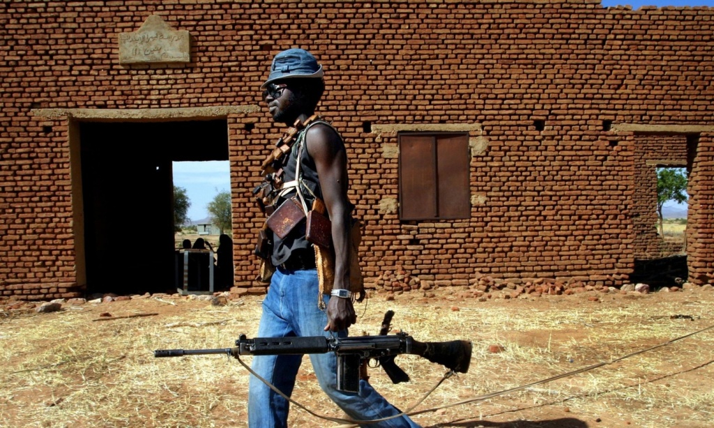 A Sudan Liberation Army rebel passes an abandoned building in the desert west of El Fasher, the capital of North Darfur state, in 2004. Photograph: Finbarr O'Reilly/RTRPIX