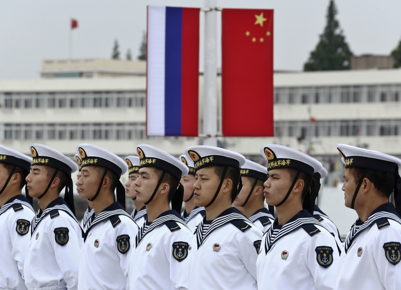 Chinese sailors stand in formation in front of national flags of Russia and China ahead of the "Joint Sea-2014" naval drill on May 18, 2014. (Courtesy Reuters)
