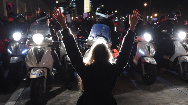 A protestor holds up her hands in front of a line of NYPD motorcycles. TIMOTHY A. CLARY/AFP/Getty Images