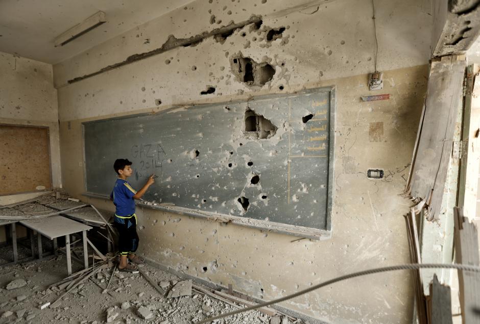 A child stands by a chalkboard in a destroyed school in Gaza. Files/J.David Ake/Mohammed Abed/Afp/Getty,Amir Cohen/Reuters/Corbis