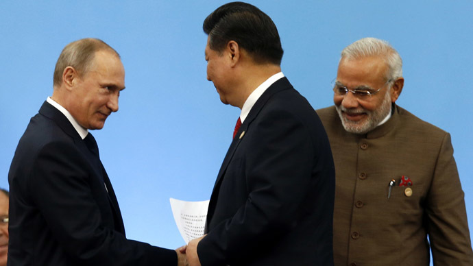 Russia's President Vladimir Putin (L) shakes hands with China's President Xi Jinping as India's Prime Minister Narendra Modi (R) looks on during the VI BRICS Summit in Fortaleza July 15, 2014. (Reuters/Paulo Whitaker)