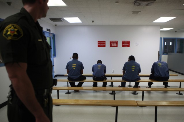 An Orange County Sheriff’s deputy keeps a watch over a group of immigration detainees. CREDIT: AP Photo / Jae C. Hong