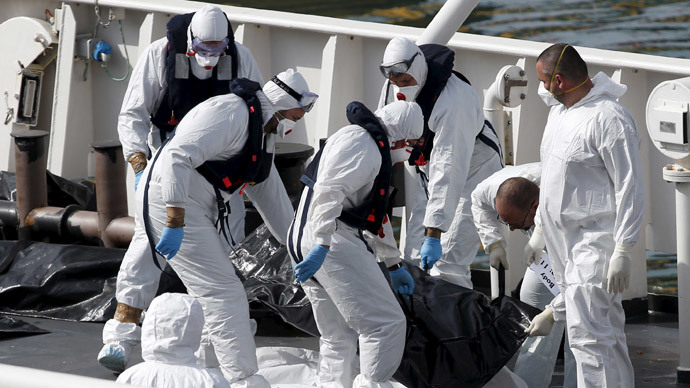 Italian coastguard personnel in protective clothing carry the body of a dead immigrant on their ship Bruno Gregoretti in Senglea, in Valletta's Grand Harbour, April 20, 2015. (Reuters / Darrin Zammit Lupi)
