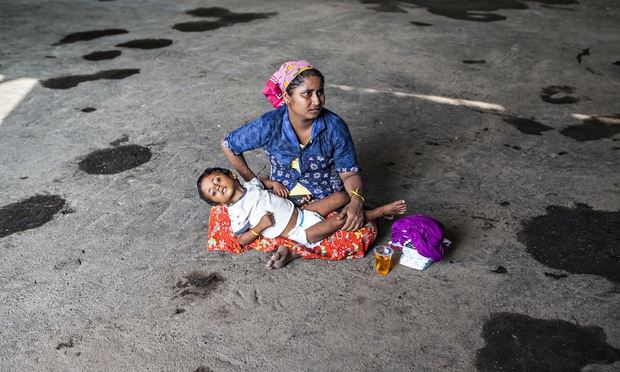Mother with child seek respite from the sun at the Langsa refugee camp. Photograph: Antonio Zambardino/Guardian