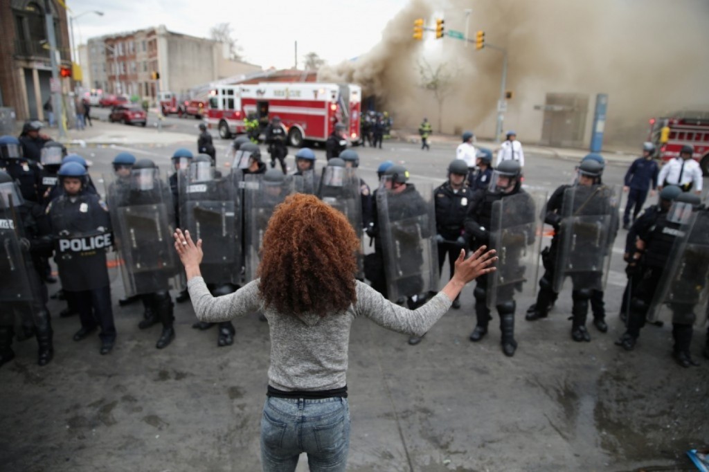 A woman faces down a line of Baltimore police officers in riot gear on Monday during protests after the funeral of Freddie Gray. (Chip Somodevilla/Getty Images)