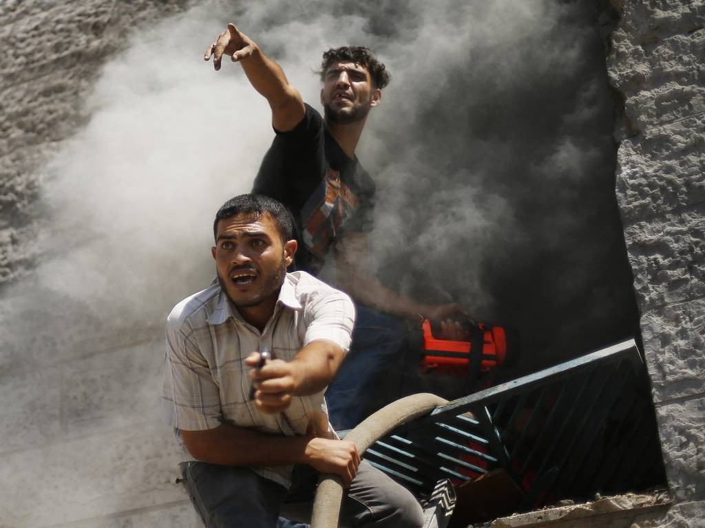 Palestinians react as they put out a fire in an apartment which witnesses said was hit by an Israeli air strike in Beit Lahiya in the northern Gaza Strip REUTERS/Mohammed Salem 