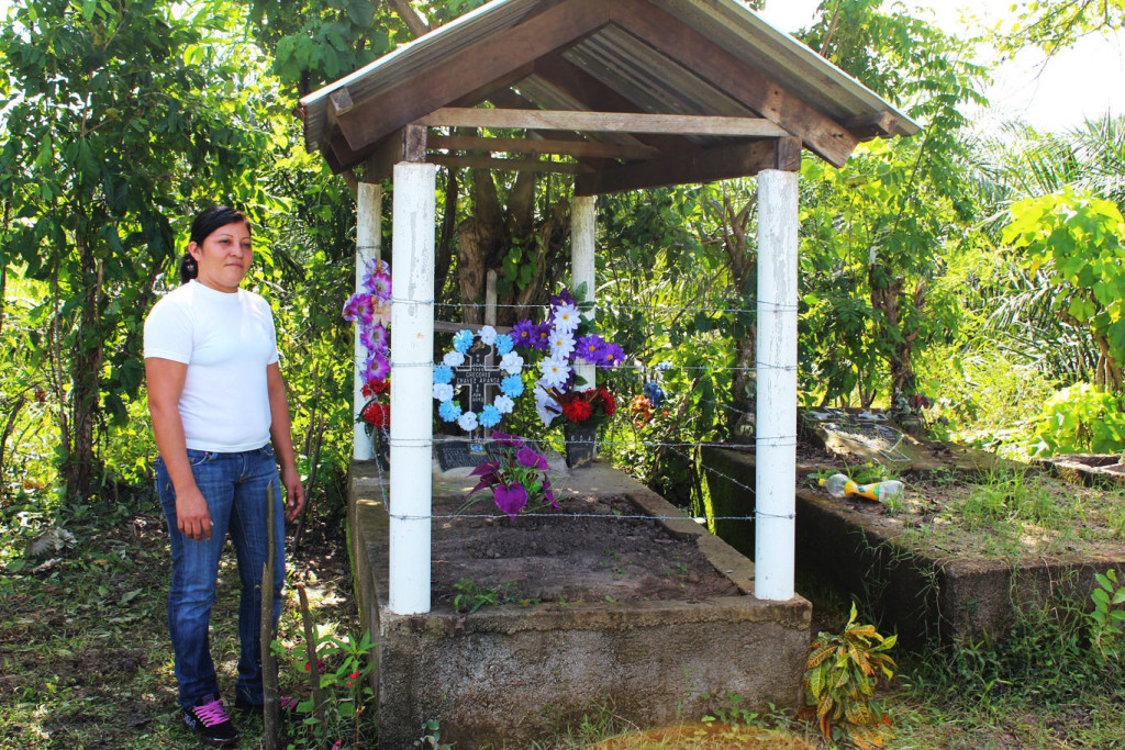 Glenda Chávez stands beside the grave of her father, the preacher Gregorio Chávez, whose body was discovered on Dinant’s Paso Aguán plantation in July 2012.International Consortium of Investigative Journalists