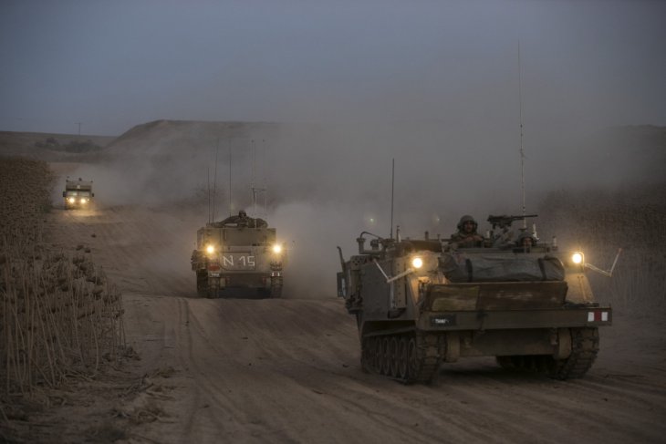 Israeli soldiers ride atop armoured personnel carriers (APCs) (C and R) near the border with the Gaza Strip August 20, 2014.REUTERS/Baz Ratner