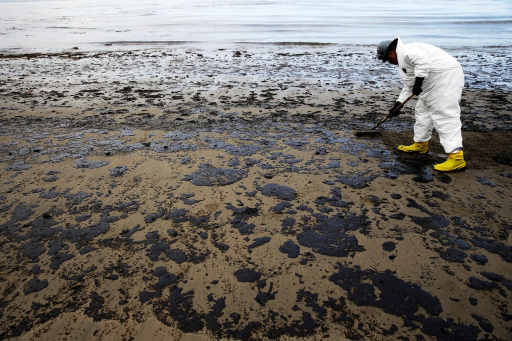 FILE - In this May 21, 2015, file photo, a worker removes oil from sand at Refugio State Beach, north of Goleta, Calif. An underground pipe, owned by Plains All American Pipeline, spewed oil down a culvert and into the Pacific on May 19 before it was shut off. Democratic U.S. Sens. Barbara Boxer and Dianne Feinstein say the response to the oil spill that blackened beaches and created a 10-square-mile slick on the ocean was "insufficient." and called on federal regulators to provide more details on the activities and decisions by Plains. (AP Photo/Jae C. Hong, File)