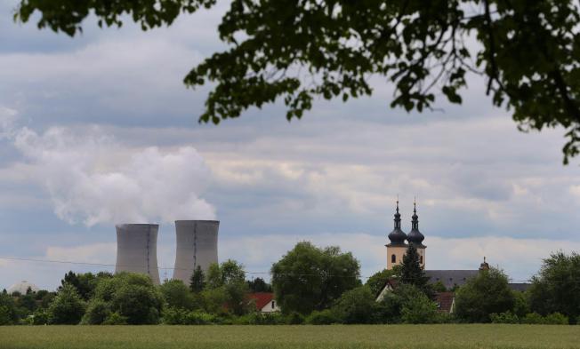 FILE - In this May 27, 2015 file photo a catholic church is pictured next to the nuclear power plant in Grafenheinfeld, southern Germany. Bavaria’s environment ministry said Sunday, June 28, 2015, Germany’s oldest remaining nuclear reactor has been shut down, part of a move initiated four years ago to switch off all its nuclear plants by 2022. (Karl-Josef Hildenbrand/dpa via AP, File)