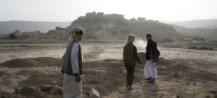 Yemeni men visit the new cemetery in Al Joob, dug specifically to accommodate the 30 men, women and children who were killed between two strikes on a public market and along a roadside. (photo: Alex Potter/The Intercept)