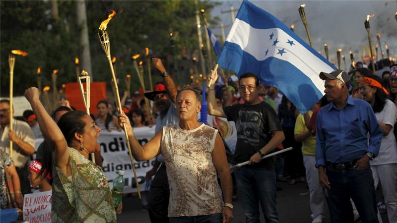 People take part in a march to demand the resignation of Honduras' President Juan Hernandez in Tegucigalpa [Reuters]
