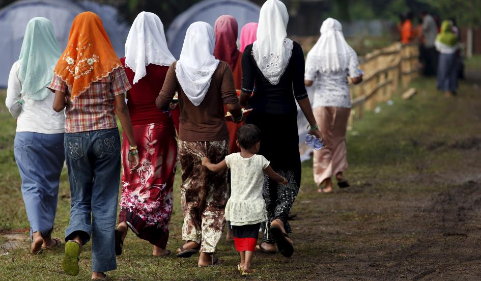 Rohingya migrants who arrived in Indonesia last week by boat walk back after collecting breakfast at a temporary shelter near Langsa on Wednesday. Darren Whiteside/Reuters