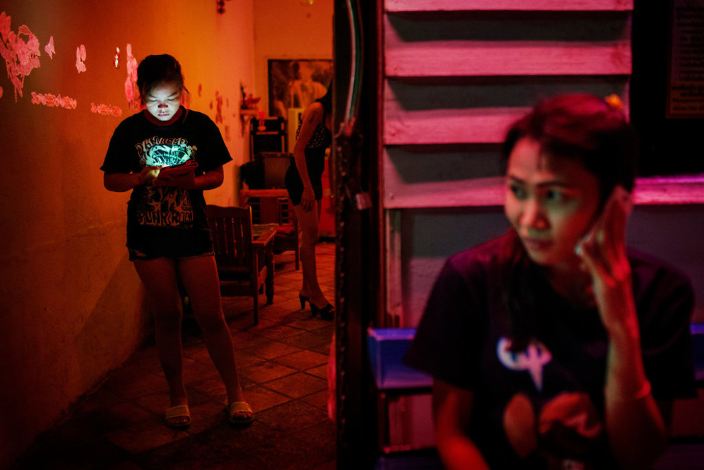 Prostitutes waited for customers outside a karaoke bar and brothel in Songkhla, Thailand. Credit Adam Dean for The New York Times