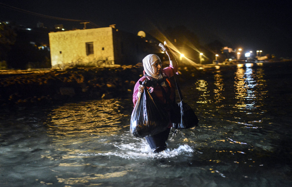 © AFP 2015/ BULENT KILIC A migrant walks to a boat to reach the Greek island of Kos on early August 18, 2015.