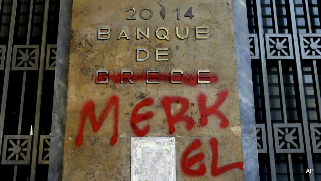 Red spray paint covers a French-language Bank of Greece sign to read ‘Bank of Merkel’ in reference to German Chancellor Angela Merkel in Athens, Monday, July 6, 2015.