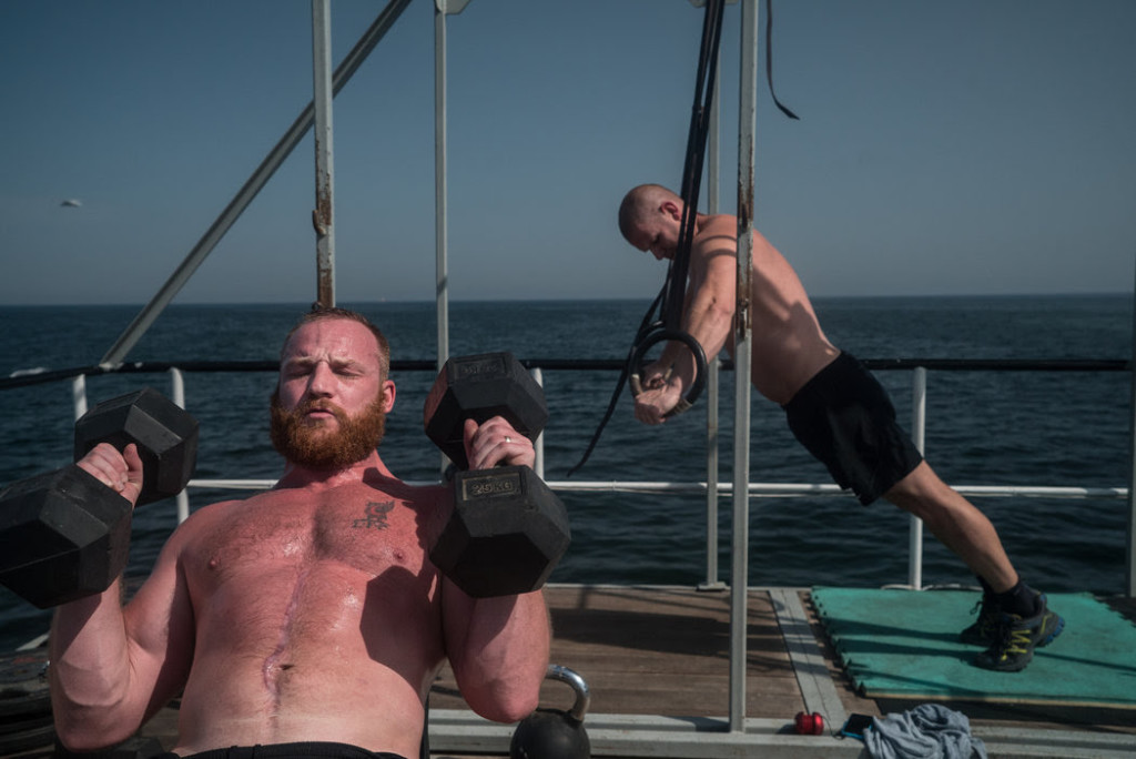 Security contractors, who face intense boredom in the long breaks between deployments, lifted weights and exercised on the deck of the Resolution. CreditBen C. Solomon/The New York Times