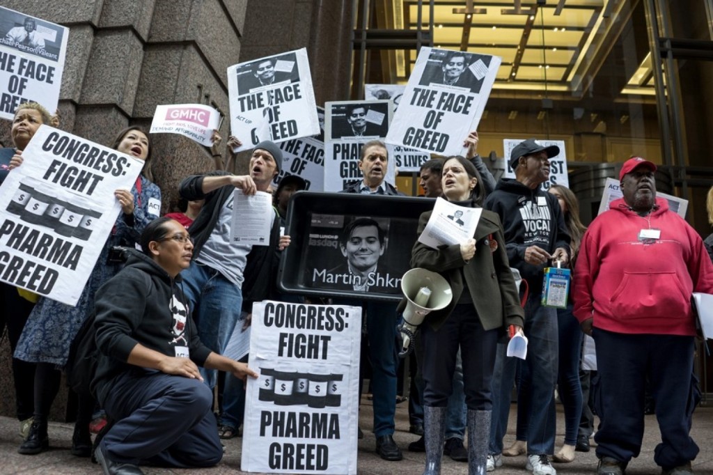  Activists hold signs containing the image of Turing Pharmaceuticals chief executive Martin Shkreli in front the New York building that houses Turing's offices on Oct. 1. (Craig Ruttle/AP)