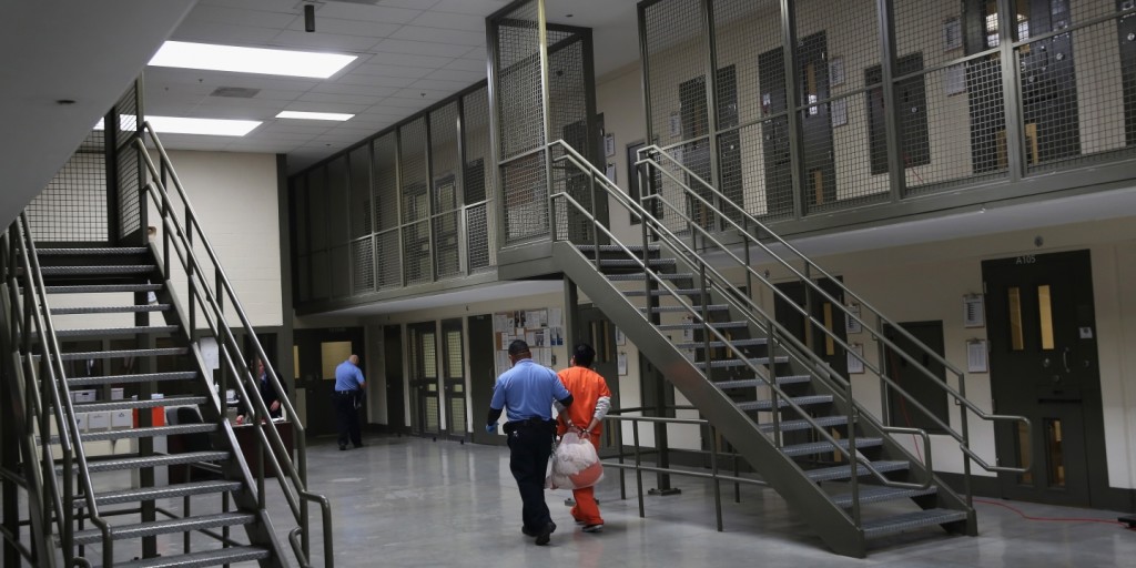 A guard escorts an immigrant detainee from his “segregation cell” at the Adelanto Detention Facility in Adelanto, California. The ICE facility is managed by the Geo Group. 