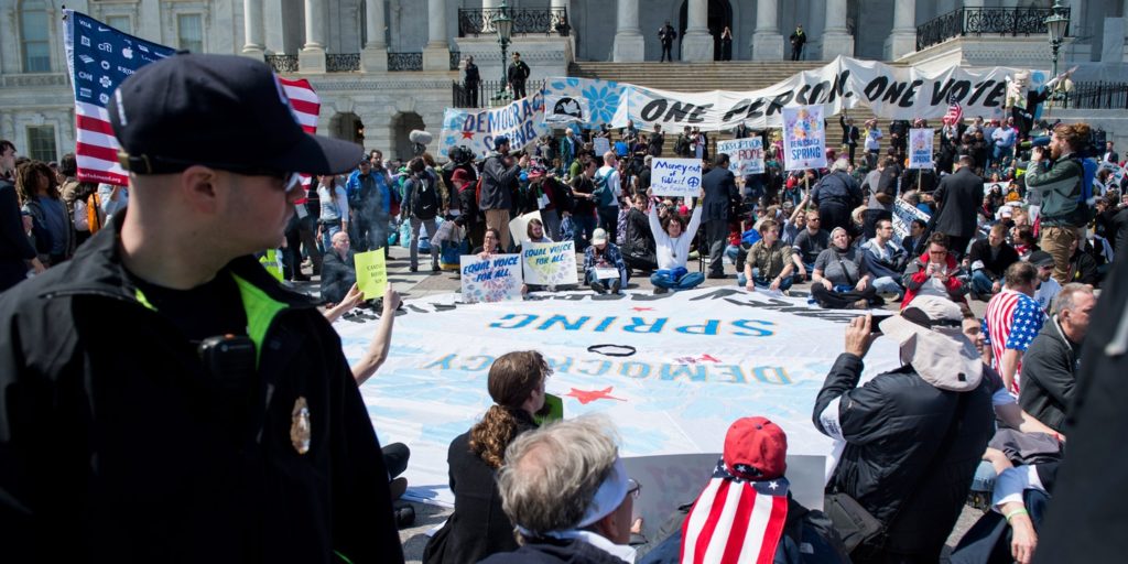 Democracy Spring protesters calling for the end of big money in politics stage a sit-in on the Capitol steps and on the East Plaza of the Capitol on April 11, 2016.
