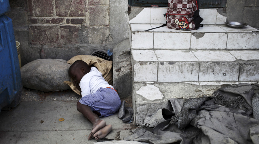 A boy takes a nap on a street in Port-au-Prince, Haiti. © Andres Martinez Casares / Reuters