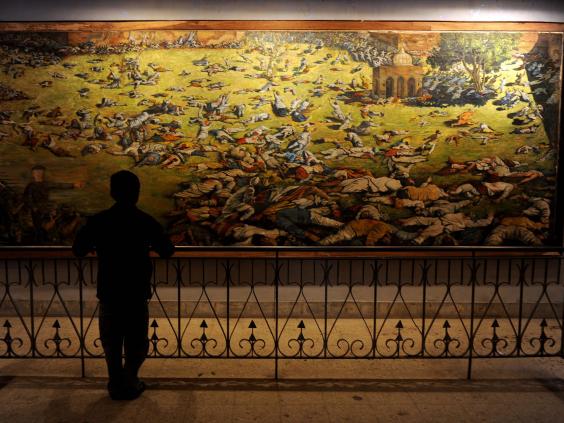 A young visitor looks at a painting depicting the Amritsar Massare at Jallianwala Bagh in Amritsar