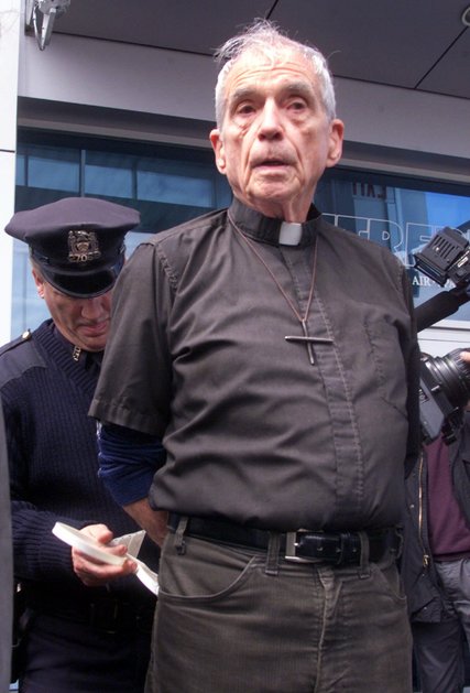 Father Berrigan being handcuffed in 2001 after he and others blocked an entrance to the Intrepid Sea, Air and Space Museum in Manhattan. Credit Richard Drew/Associated Press