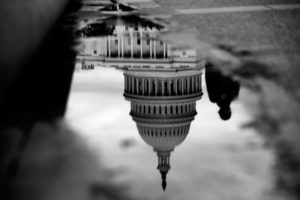 The U.S. Capitol is reflected in a puddle next to the Capitol Reflecting Pool in Washington, D.C., Oct. 15, 2013. Photo: Andrew Harrer/Bloomberg/Getty Images