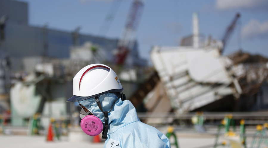 A Tokyo Electric Power Co. (TEPCO) employee, wearing a protective suit and a mask, walks in front of the No. 1 reactor building at TEPCO's tsunami-crippled Fukushima Daiichi nuclear power plant in Okuma town, Fukushima prefecture, Japan February 10, 2016. © Toru Hanai / Reuters