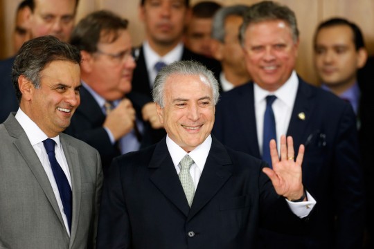 Interim President Michel Temer waves with Sen. Aécio Neves, left, at a signing ceremony for new government ministers at the presidential palace in Brasília, May 12, 2016. Photo: Igo Estrela/Getty Images