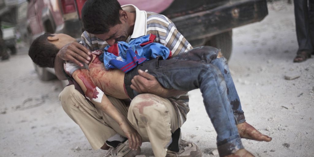 A Syrian man holds the body of his son, killed by the Syrian Army, near Dar El Shifa hospital in Aleppo on Oct. 3, 2012.