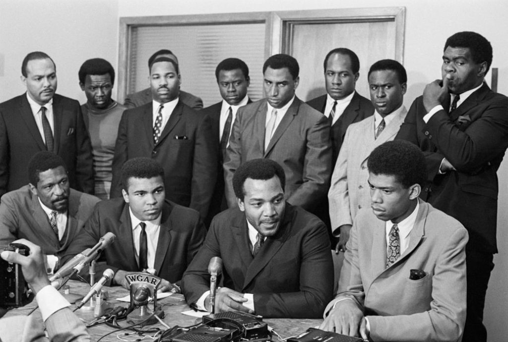 Muhammad Ali and other athletes gather at a news conference after Ali rejected Army induction in 1967. Bettmann/Getty