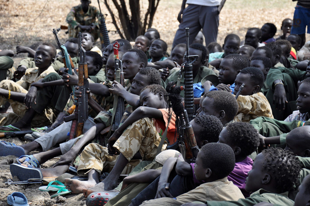 Boys sit with their rifles at a ceremony for demobilizing and reintegrating child soldiers in Pibor, South Sudan, on Feb. 10, 2015. Photo: Samir Bol/Anadolu Agency/Getty Images