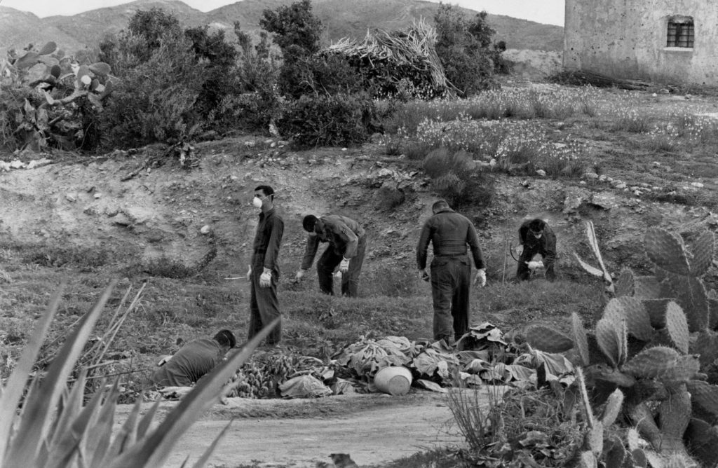 Air Force personnel wearing masks and gloves working in the fields where three of the bombs were found. Credit U.S. Air Force