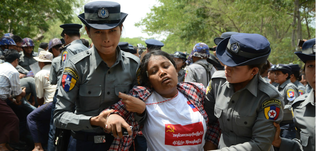 In the photo, a labor demonstrator is arrested by police in Tetkone township on May 18, during a protest march to central Naypyidaw. Photo credit: AUNG HTET/AFP/Getty Images